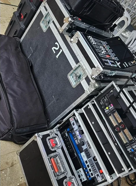 Cases rodantes con consola digital, racks de procesamiento y receptores de micrófonos inalámbricos