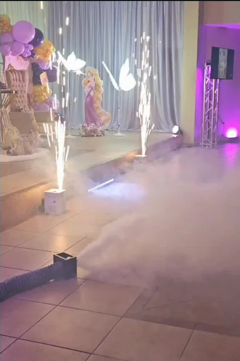 Chispa fría y humo bajo en un quinceañero, con uplighting morado y torre de truss