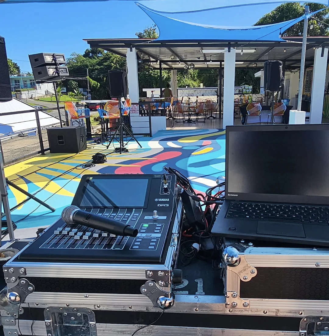 Consola digital Yamaha DM3 con laptop controlando el sistema en un evento al aire libre